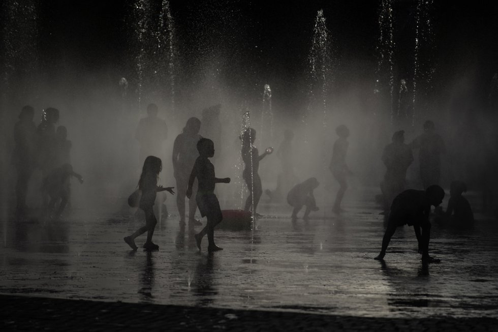 Varias personas se refrescan en las fuentes de Madrid Río, a 23 de junio de 2026, en Madrid (España).