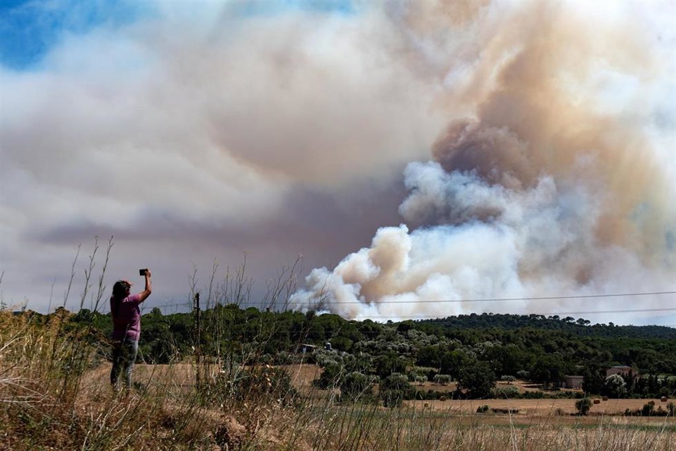 Una persona le hace una foto al humo del incendio, en La Bisbal d'Empordà, Girona, Catalunya (España). Protecció Civil ha enviado una alerta de forma preventiva por la evolución del fuego, así como la presencia de humo y para evitar la movilidad en la zon