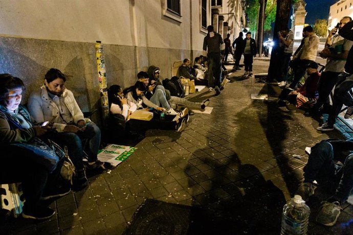 Archivo - Varias personas hacen cola nocturna para conseguir el certificado de vulnerabilidad en una Oficina de Asistencia en Materia de Registro.