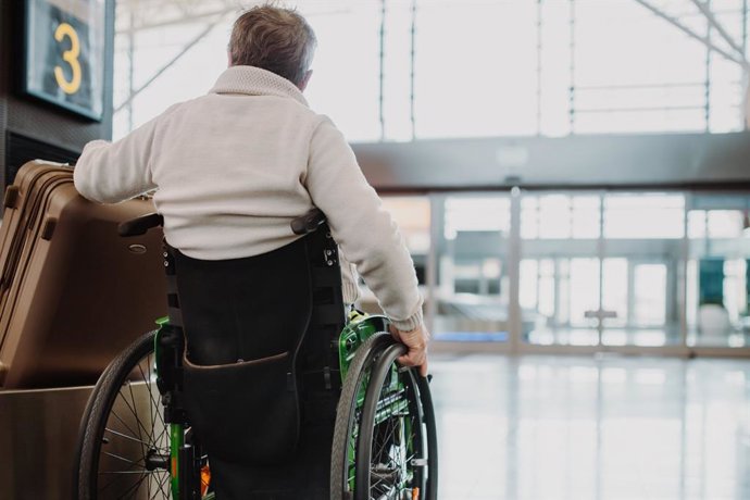 Archivo - Un usuario en silla de ruedas en un aeropuerto.