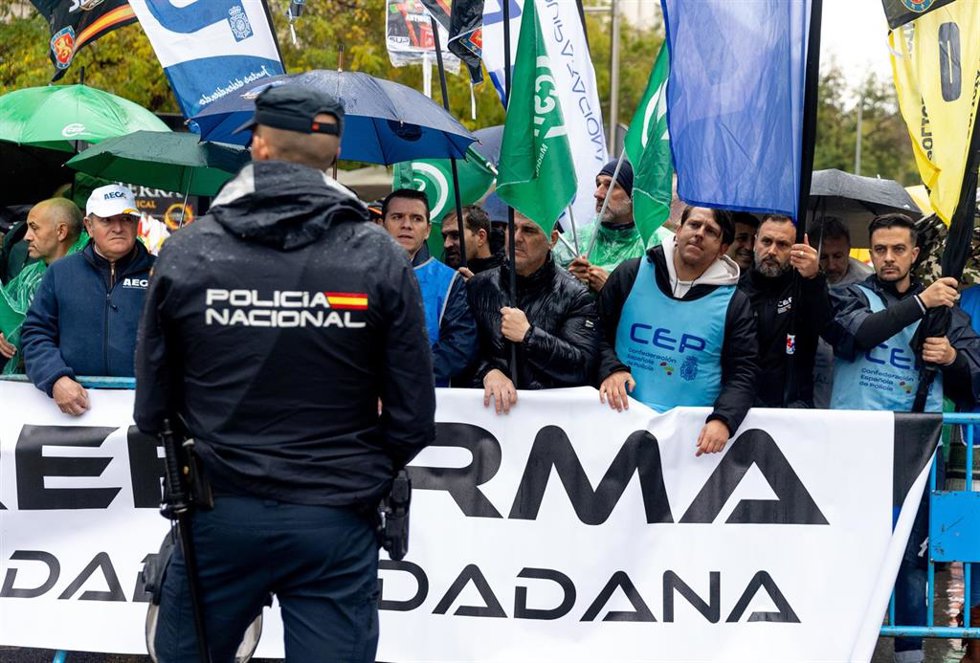 Archivo - Un agente de Policía Nacional delante de una concentración 