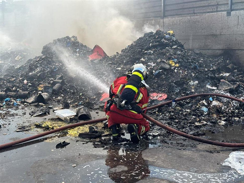 Bomberos de la Comunidad de Madrid trabajan en la extinción de un incendio en el exterior de una nave de reciclaje en Loeches.