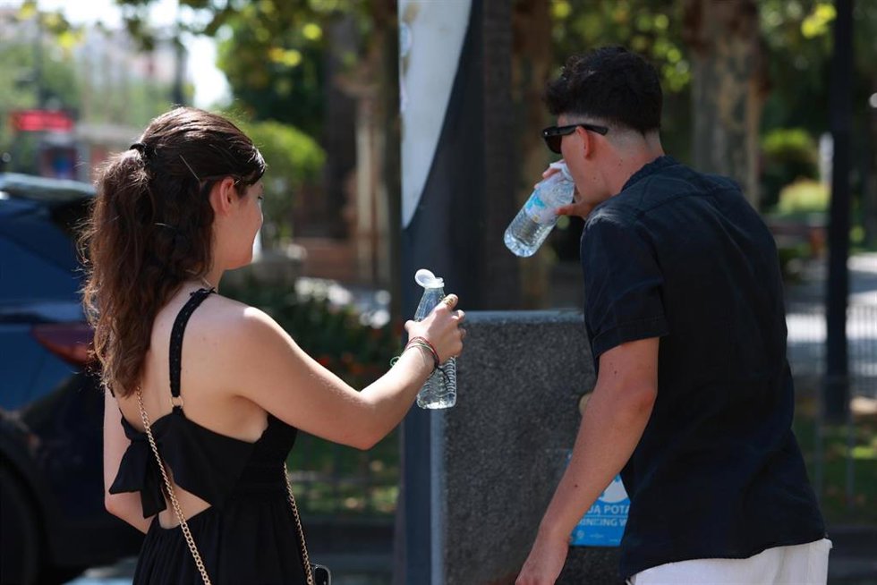 Una pareja bebe agua durante la ola de calor. 