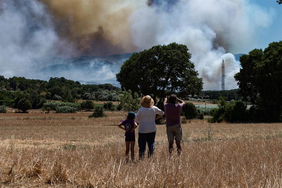 Varias personas observan el humo del incendio, en La Bisbal d'Empordà, Girona, Catalunya (España). 