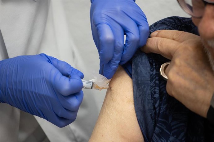 Archivo - Una mujer se vacuna durante el inicio de la campaña de vacunación de la gripe en un centro de salud de Madrid