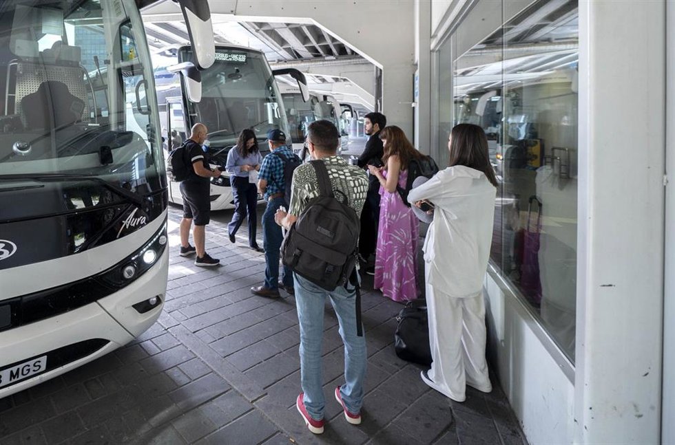 Archivo - Un grupo de personas esperan a subir a un autobús de media distancia en foto de recurso
