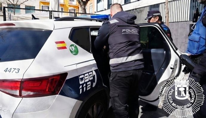 Archivo - Agentes de la Policía Municipal de Madrid junto a un coche patrulla