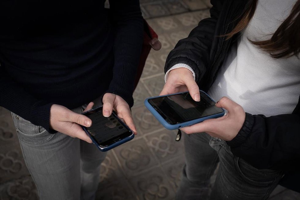 Archivo - Dos personas usan el teléfono móvil, a 1 de febrero de 2024, en Barcelona, Catalunya (España). El pasado 30 de enero el Govern aprobó las instrucciones que regulan el uso de los dispositivos móviles en las aulas de colegios e institutos, que se 