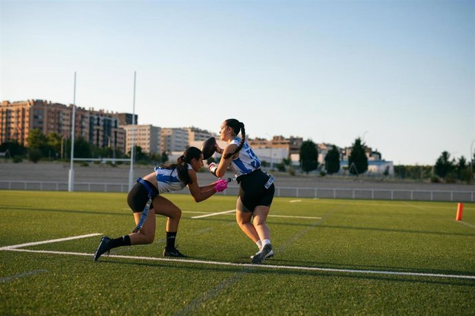 Imagen de dos jugadores jugando al 'flag football' durante el evento 'Flag for Fun: El Gran Encuentro del Deporte Comunitario' celebado en Madrid
