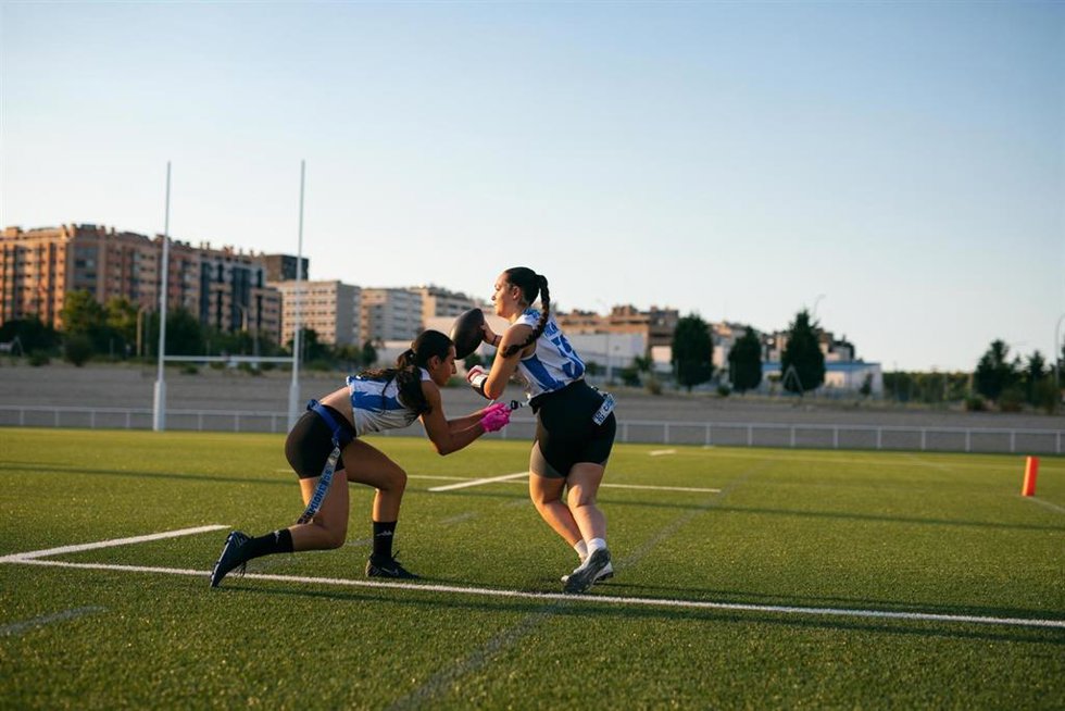 Imagen de dos jugadores jugando al 'flag football' durante el evento 'Flag for Fun: El Gran Encuentro del Deporte Comunitario' celebado en Madrid