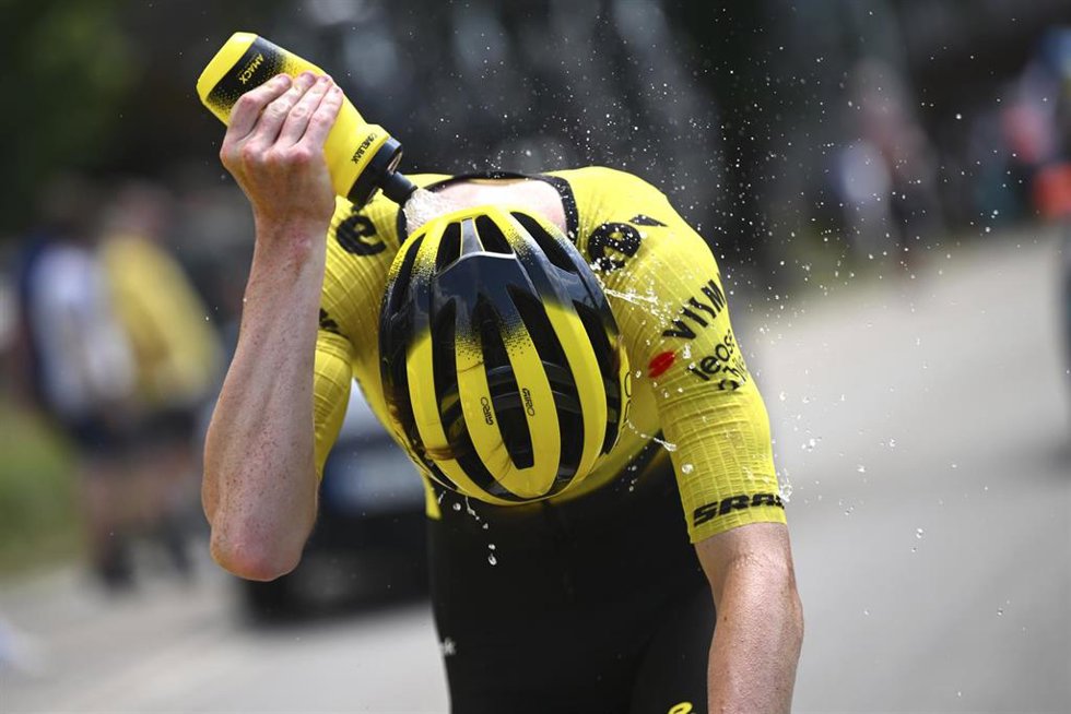 Un ciclista del Visma | Lease a Bike se moja con un botellín de agua