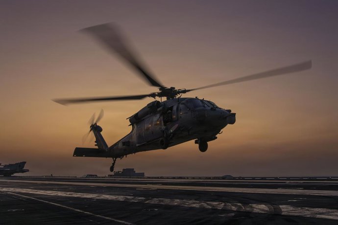 Archivo - March 6, 2026, Undisclosed Location, United States: A U.S. Navy MH-60S Sea Hawk helicopter, attached to the Chargers of Helicopter Sea Combat Squadron 14, silhouetted by the sunset, takes off from the flight deck of the Nimitz-class aircraft car