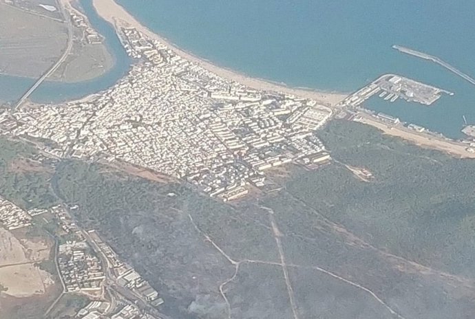 Vista aérea de Barbate donde se ve con humo la zona del incendio declarado en la tarde del martes 7 de julio.