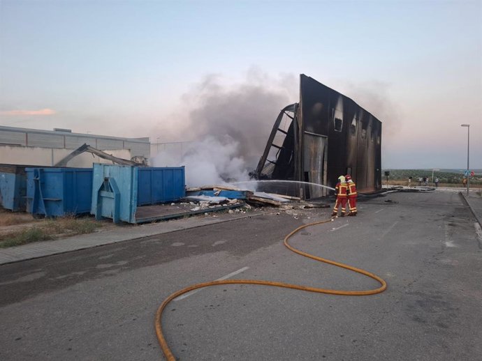 Bomberos actúan de madrugada en el incendio en una nave de Paradas (Sevilla) que ha quedado completamente dañada Bomberos trabajando en el incendio de la nave en Paradas, Sevilla, con llamas visibles y humo denso