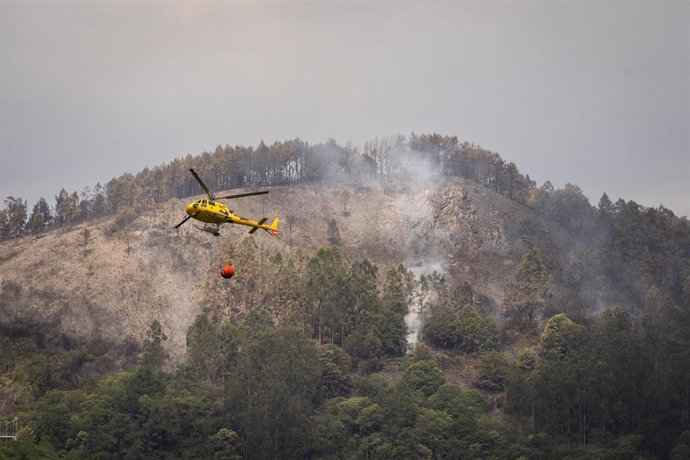 Helicóptero durante las labores de extinción de un incendio forestal, a 14 de junio de 2026, en Grado, Asturias (España). 