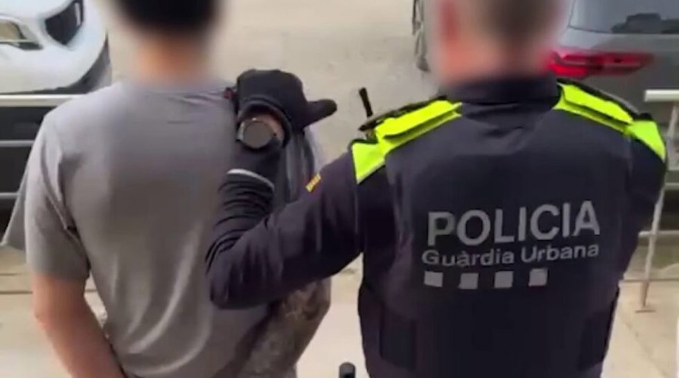 Un agente de la Guardia Urbana de Barcelona (GUB) custodia uno de los 18 detenidos miembros de un grupo juvenil "violento" con epicentro de Barcelona y su área metropolitana dedicado al tráfico de drogas