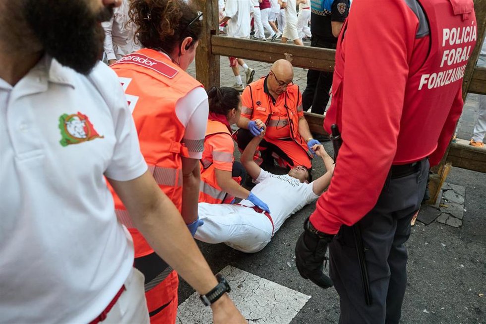 Voluntarios de Cruz Roja atienden a un corredor tras el segundo encierro de los Sanfermines 2026.