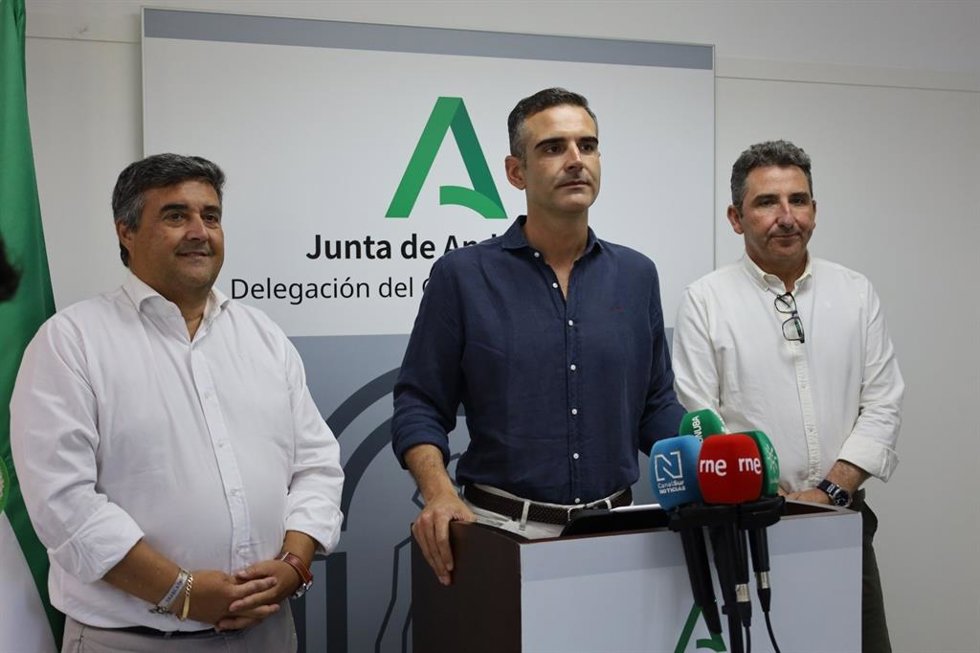El consejero de Agricultura, Pesca, Agua y Desarrollo Rural en funciones, Ramón Fernández-Pacheco (centro), en una atención a medios en Huelva.