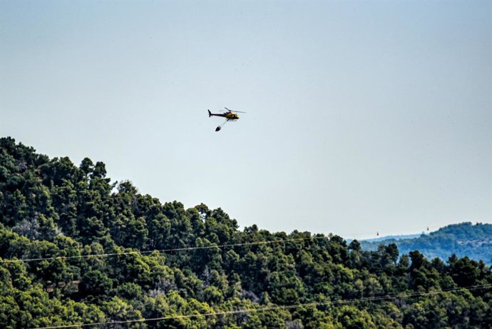 Un helicòpter sobrevola terrenys cremats a Sentmenat, Barcelona