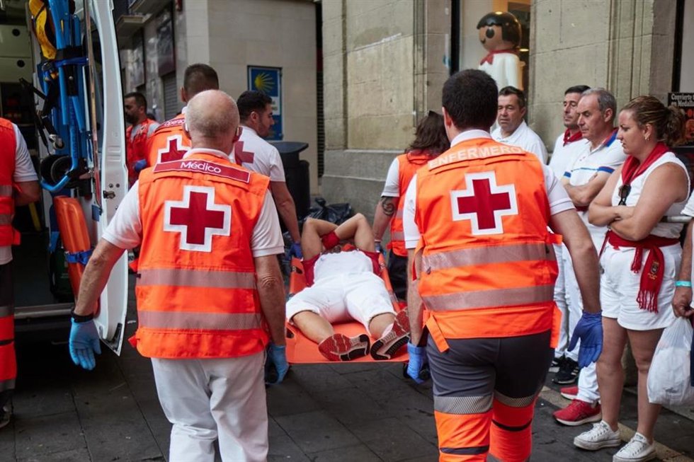 Voluntarios de Cruz Roja atienden a un corredor herido tras el tercer encierro de los Sanfermines 2026 con toros de Victoriano del Río.