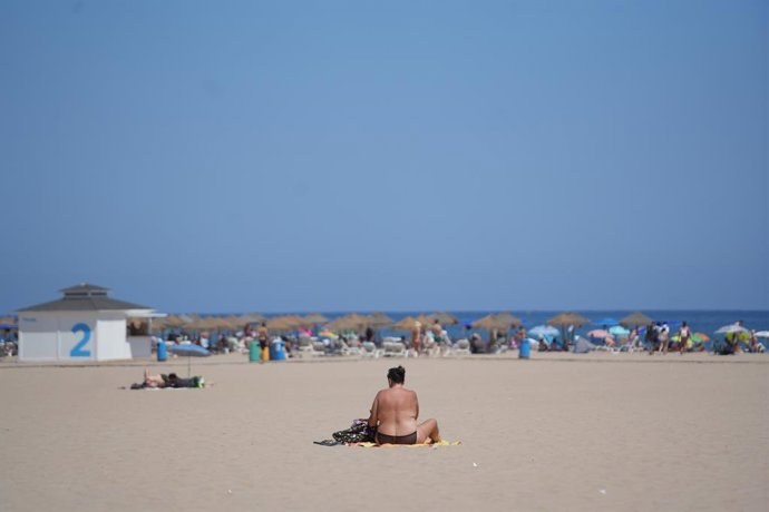 Archivo - Una persona asseguda a la platja