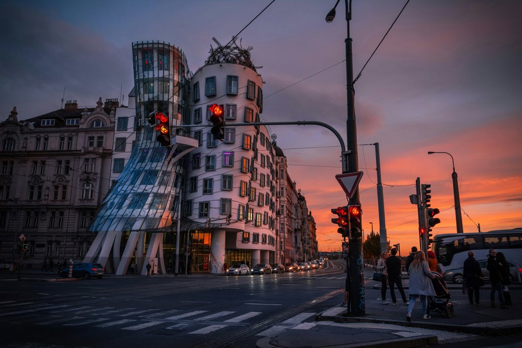 Ciudad contemporánea al anochecer, con tráfico y arquitectura urbana.