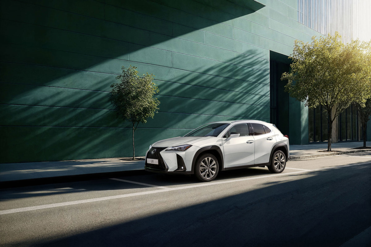 Lexus UX 300h blanco aparcado en un entorno urbano contemporáneo.
