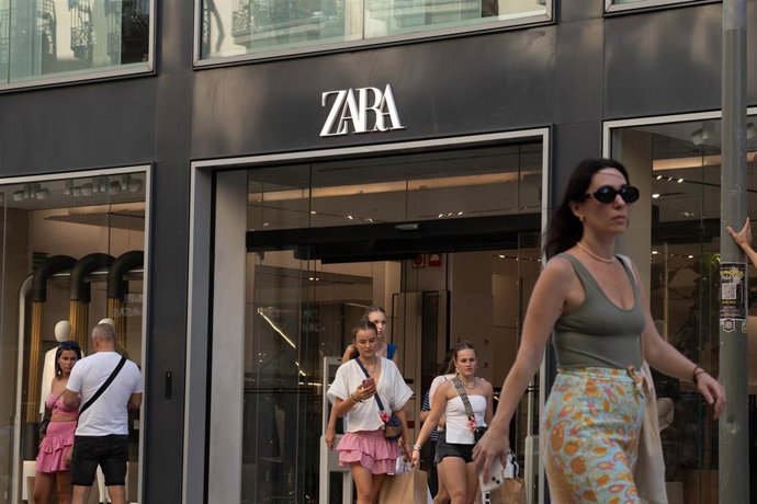 Archivo - Varias personas pasan delante de una tienda Zara