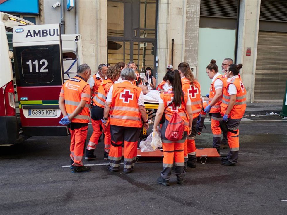 Voluntarios de Cruz Roja atienden a un corredor herido en el tercer encierro de los Sanfermines 2026.