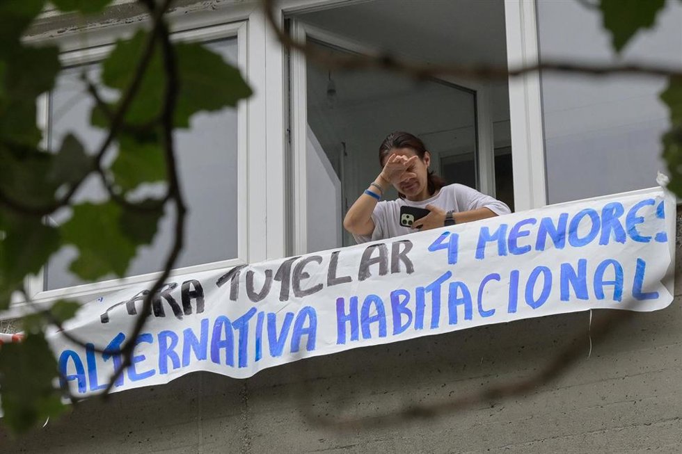 La mujer ucraniana con cuatro hijos menores, asomada en la ventana de la vivienda tras el aplazamiento del desahucio.