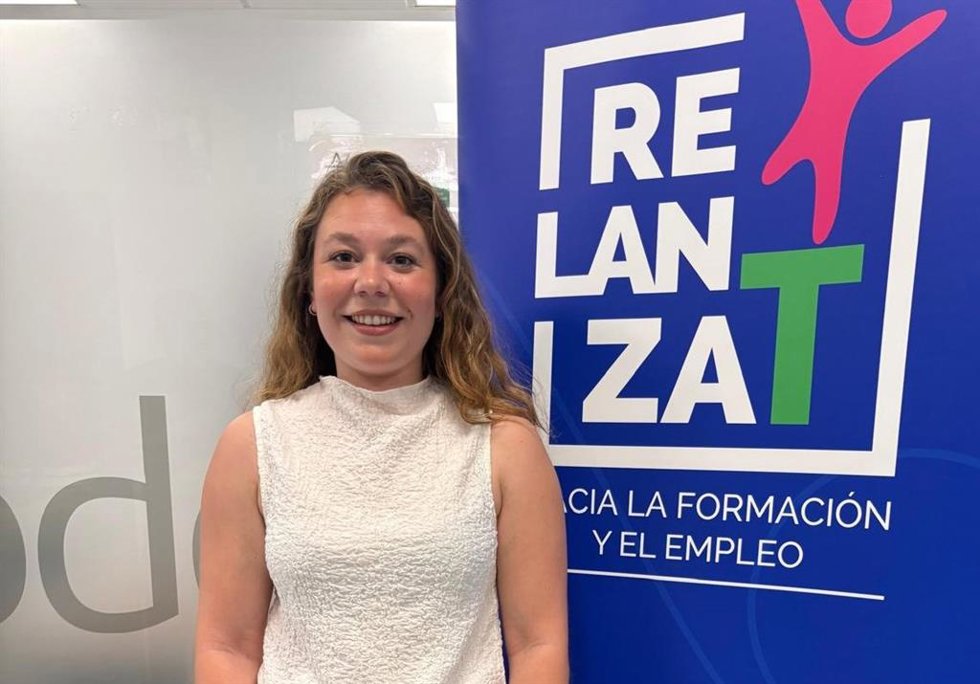 La delegada de Empleo de Alcalá de Guadaíra (Sevilla), Paula Fuster, junto al cártel de RELANZA-T