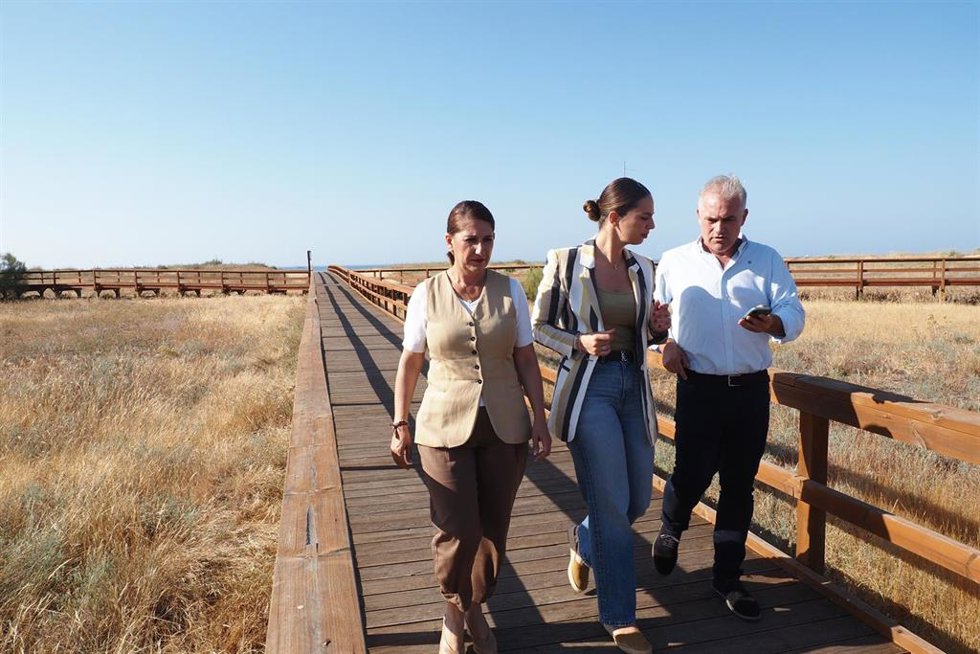 La alcaldesa de Palos de la Frontera (Huelva), Milagros Romero (centro), en una visita a Mazagón.