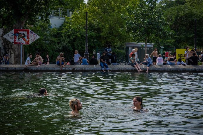 Imagem de arquivo mostrando várias pessoas em um canal de Paris durante a onda de calor.