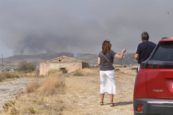 Dos personas observan el avance del incendio forestal, a 10 de julio de 2026, en Los Gallardos, Almería, Andalucía (España). 