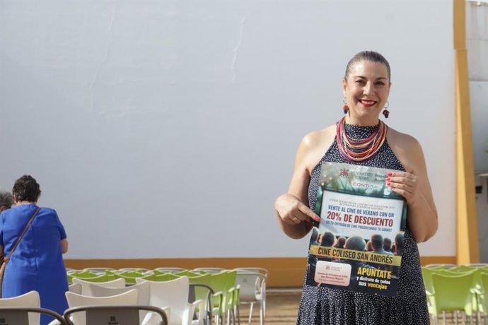 Eva Contador, en el cine de verano Coliseo San Andrés, muestra un cartel informativo sobre el descuento ofrecido a los mayores.