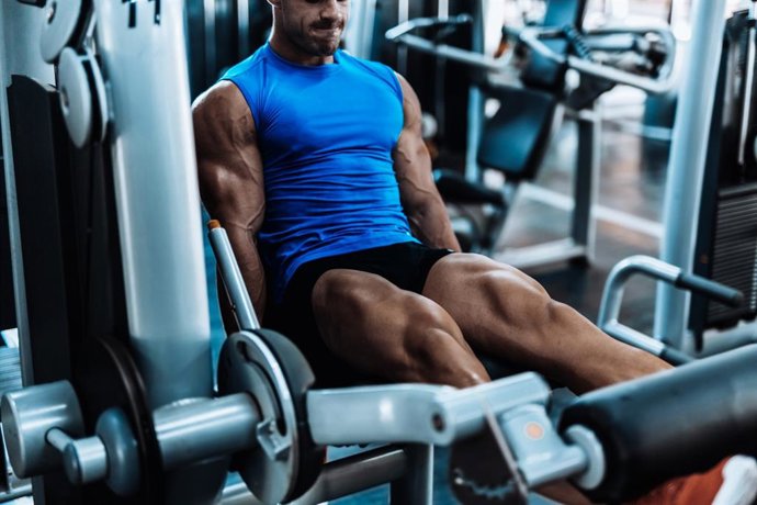 Archivo - Hombre haciendo ejercicio de piernas en el gimnasio.