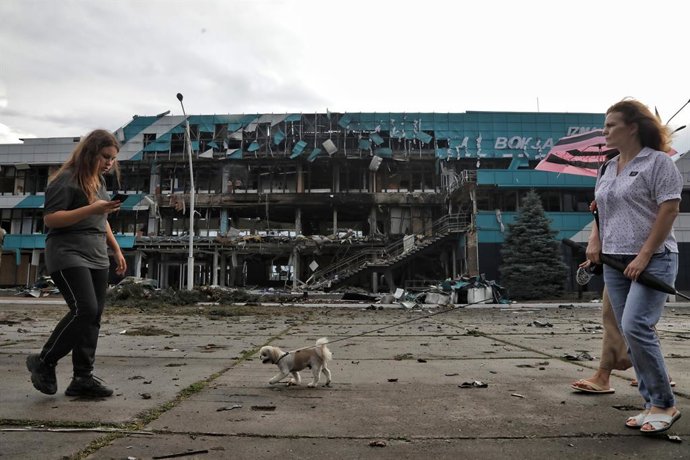 Archivo - FILED - 02 August 2023, Ukraine, Izmail: A woman walks a dog outside the building of the Marine Terminal damaged in the Russian drone attack on the port infrastructure of Izmail situated on the Danube River Wednesday night. Photo: -/Ukrinform/dp