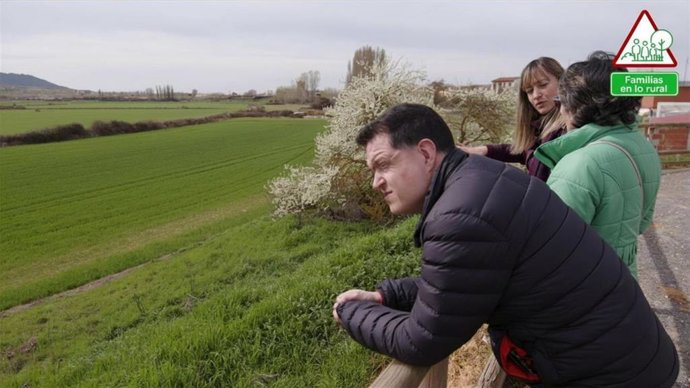 Víctor Varona observa el paisaje junto a su madre, Fina Aroz, y otra mujer, en el entorno rural de Venta de Baños (Palencia).