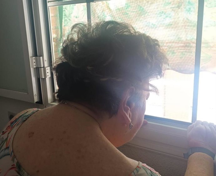 Teresa se asoma a la ventana de su casa.