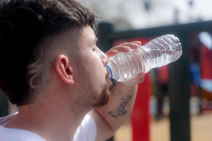 Archivo - Un joven bebe de una botella de agua.