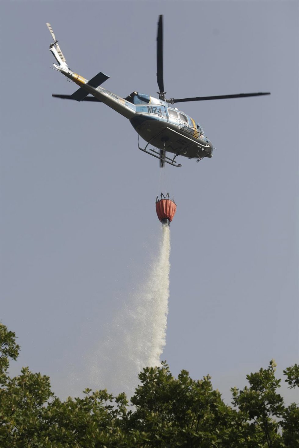 Archivo - Helicóptero bombardero continúa con la tareas de extinción para sofocar el incendio forestal.