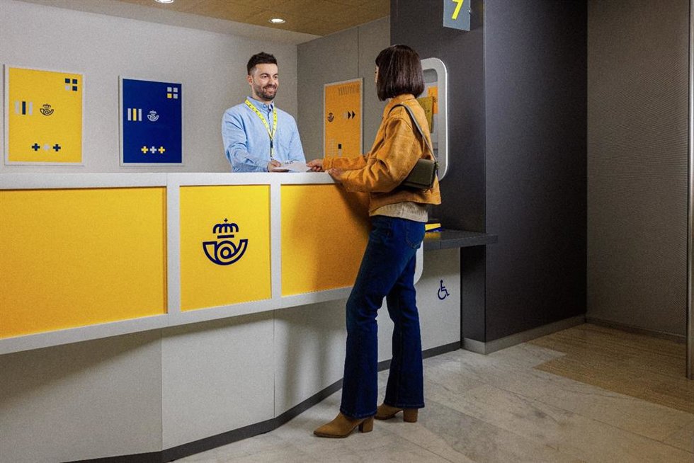 Un trabajador de Correos atiende a una persona.
