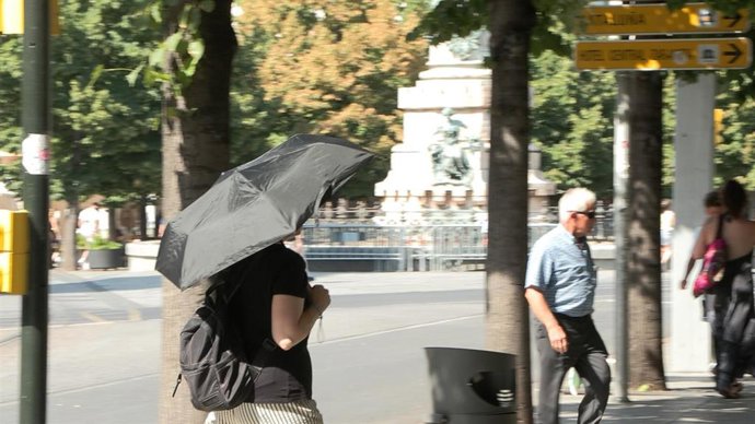 Mujer con paraguas en Zaragoza para refugiarse del sol.