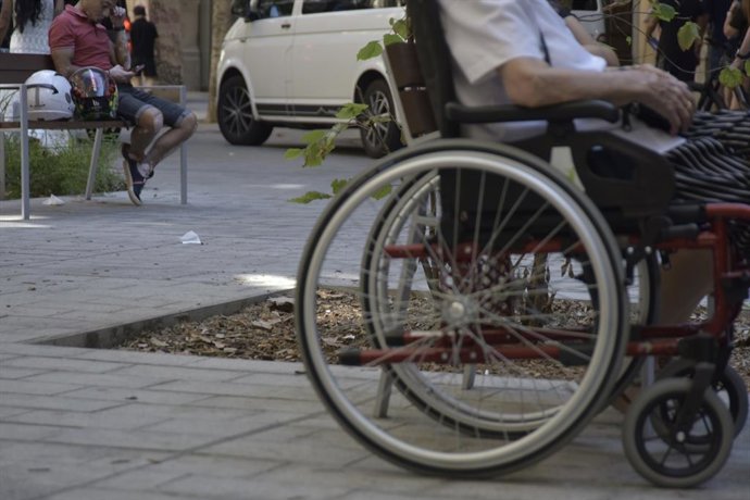 Archivo - (Foto de ARCHIVO) Una persona en silla de ruedas en la calle Consell de Cent, a 8 de septiembre de 2023, en Barcelona