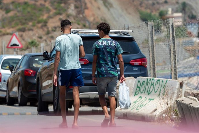 Archivo - Dos migrantes pasean por la calle, en imagen de archivo.