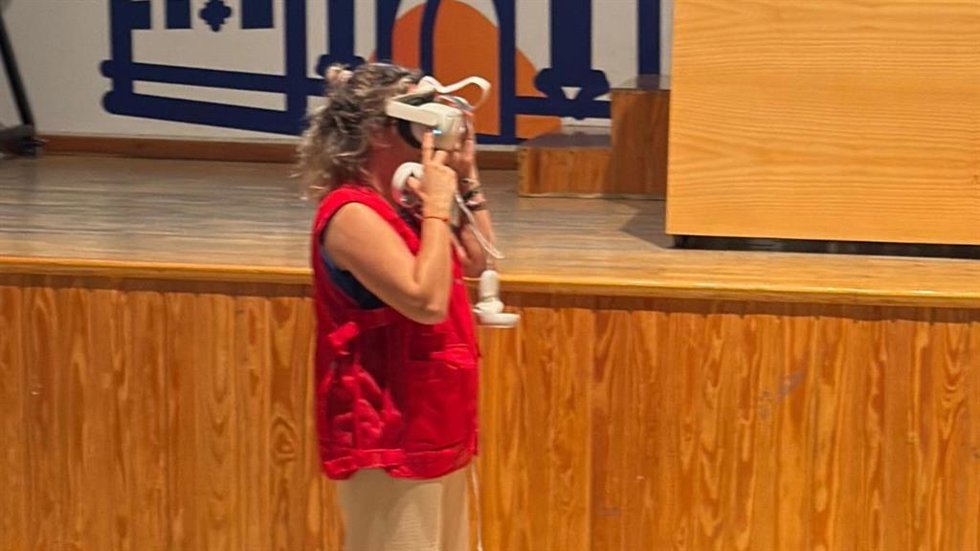 Una integrante de Cruz Roja prueba unas gafas de realidad virtual en el taller de ciberseguridad dirigido a menores de la Universidad Popular de Alcalá de Guadaíra (Sevilla).