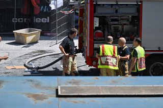 14 July 2026, Belgium, Brussels: Emergency workers secure the scene of a fatal fire at the OXY building undergoing renovation near Place De Brouckere. According to the local labour inspection service, several bodies were discovered inside a lift shaft aft