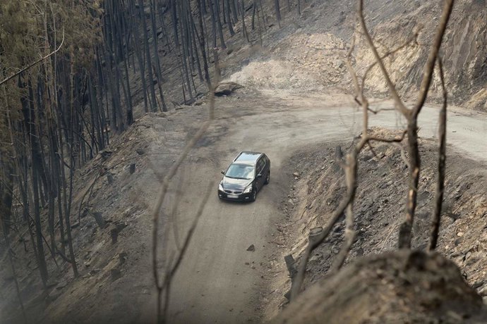Archivo - Un coche circula al lado del terreno calcinado, a 20 de septiembre de 2025, en A Barca, Sober, Lugo, Galicia (España). La conselleira do Medio Rural, María José Gómez, ha explicado que las llamas de este incendio forestal calcinaron varias casas
