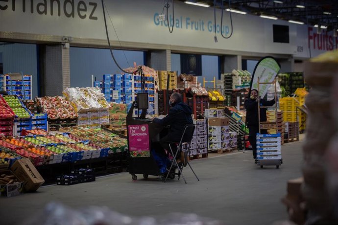 Archivo - Un hombre trabaja frente a un puesto de frutas en Mercabarna, en Barcelona, Catalunya (España), a 9 de diciembre de 2020. Hoy ha tenido lugar la inauguración de Biomarket, el primer mercado mayorista de España y el segundo en Europa exclusivamen