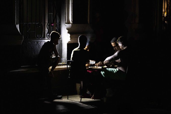 10 de julho de 2026, Havana, Cuba: HAVANA, CUBA – 10 E 11 DE JULHO DE 2026: Moradores de Havana jogam dominó na rua durante o apagão. Os moradores lidam com cortes generalizados de energia durante o quarto apagão nacional de Cuba em 2026 e o segundo w